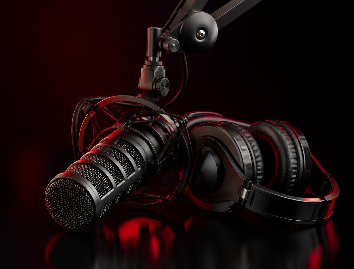 Broadcast microphone and headphones lit in red inside the AMM Radio studio